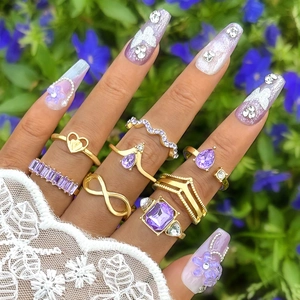 Detail of 8pcs bohemian gold ring set featuring purple gemstones and infinity symbols