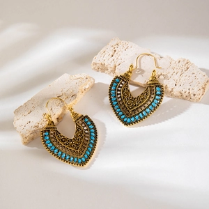 Detail of bohemian heart earrings with blue beads on textured stones
