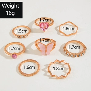 Detailed view of rose gold stacking rings set with butterfly and heart crystal motifs
