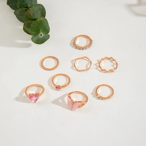 Detailed view of 7-piece rose gold ring set featuring pink zircon heart and butterfly designs