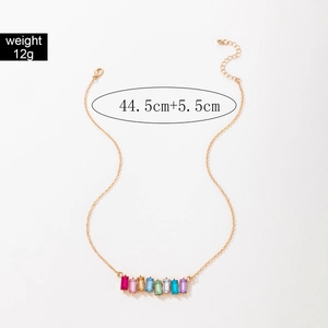 Close-up of golden necklace with colorful rectangular gemstones and chain length details