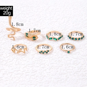 Detailed view of vintage gold snake rings and green gemstone set with size dimensions