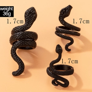 Macro detail of three black snake-shaped punk rings with realistic scale textures