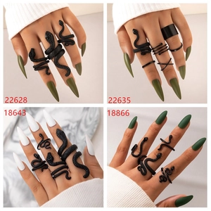 Detailed view of matte black snake-shaped and geometric ring set in gothic punk style