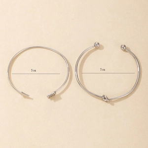 Détail de l'ensemble de bracelets flèche et nœud argentés avec mesure de 7cm de diamètre