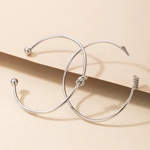 Gros plan d'un ensemble de bracelets argentés aux détails de nœuds et flèches