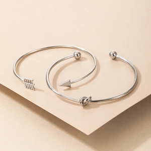 Détails de l'ensemble de bracelets joncs argentés à nœud et flèche au fini poli géométrique