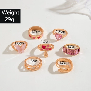 Detailed set of 7 gold rings featuring pink mushroom, butterfly and gemstone charms