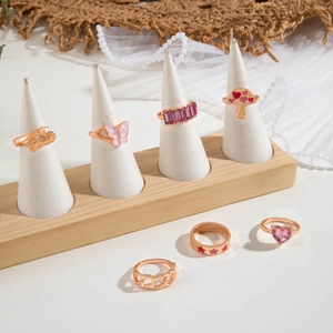 Set of 7 rose gold rings with pink butterfly and purple gemstone details on display
