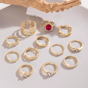 Vista detallada del set de 11 anillos dorados con setas rosas y piedras brillantes