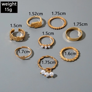Detailed view of a 7-piece gold butterfly and pearl joint ring set with size specifications