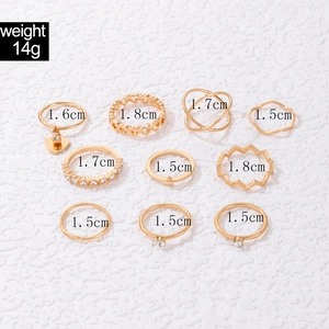 Detailed view of a 10-piece gold ring set with heart charms, faux pearls and crystals
