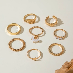 Detailed overhead view of 8-piece gold-tone alloy rings set with pearls and star motifs