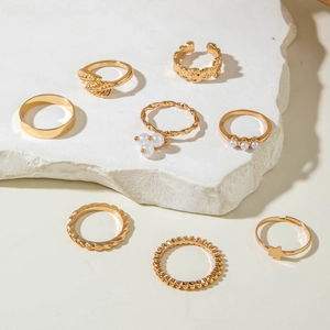 Detailed view of an 8-piece gold butterfly ring set with stars and faux pearls