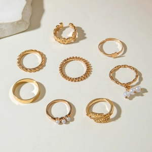 Detailed view of an 8-piece gold butterfly and star stacking ring set with pearls