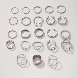 Detailed flat lay of 23 silver butterfly and heart stacking rings in various styles