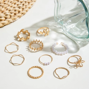 Detailed view of 10-piece gold plated ring set with pearls and leaf designs