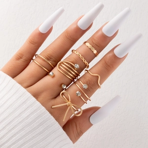 Close-up of seven gold-plated fashion rings with rhinestones on a hand model