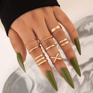 Close-up of 9-piece gold-tone ring set featuring cross and twisted band designs