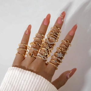 Close-up of bohemian gold rings with heart and butterfly charms on a hand