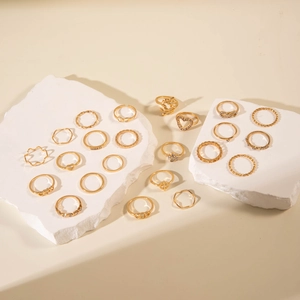 Detail view of 20pcs gold geometric ring set with heart and pearl motifs on stone slabs