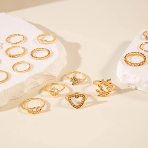 Close-up of gold ring set featuring heart, leaf, and pearl details on stone displays