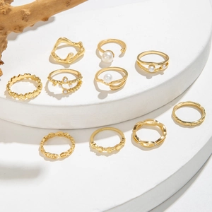Dettaglio di un set di 10 anelli placcati in oro con perle sintetiche e forme geometriche
