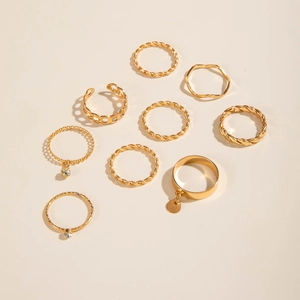 Detail of 9-piece gold-tone stacking ring set featuring chain and pendant designs