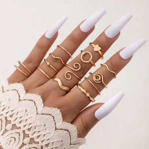 Detail of 13-piece gold butterfly and heart ring set worn with elegant lace sleeves