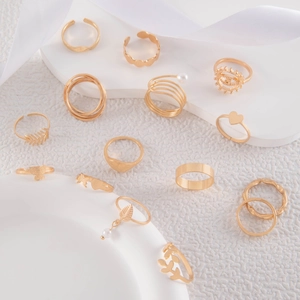 Detailed view of 14pcs gold butterfly and heart ring set on white silk background