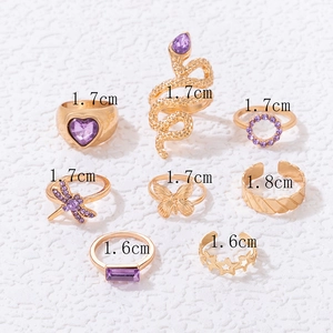 8-piece gold-toned ring set featuring purple gems, snake, heart, and butterfly designs