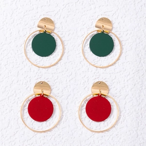 Detalle de pendientes geométricos redondos en acabado esmaltado verde oscuro y rojo