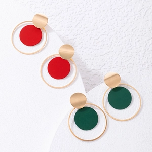 Primer plano de pendientes de aro geométricos con colgantes circulares rojos y verdes
