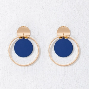 Detalle de pendientes de círculo dorado con aro grande y colgante redondo azul mate