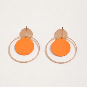 Detalle de los pendientes de aro dorados con un disco naranja mate para mujer
