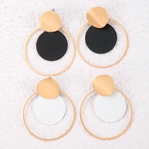 Detalle de pendientes redondos geométricos en conjunto negro-oro y blanco-oro