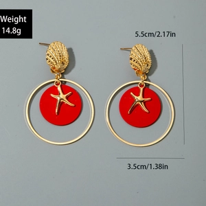 Detalle de pendientes de estrella de mar y concha dorados con disco rojo y medidas