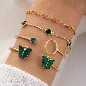 Ensemble de cinq bracelets dorés avec breloques papillon et pierres précieuses vertes