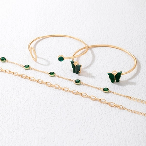 Détails de 4 bracelets dorés avec motifs papillons verts et accents de pierres fines