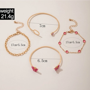 Détail du set de bijoux dorés 4 pièces avec papillon rose et pierres précieuses