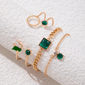 Détail d'un ensemble de bijoux dorés 4 pièces avec cristaux verts et motif papillon
