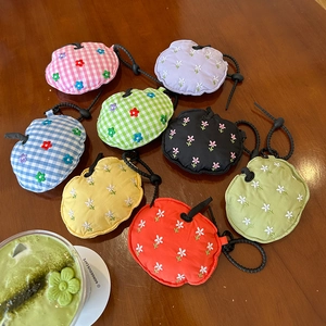 Detail of colorful floral embroidered mini fruit-shaped earphone pouches with drawstrings