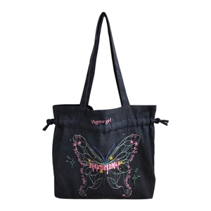 Denim tote bag with bow embroidery, drawstring closure, and chain strap in black