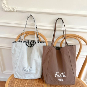 Detail view of large canvas tote bags with leopard print lining and Faith mole print
