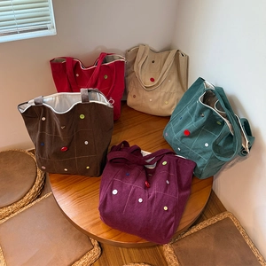 Detailed collection of corduroy tote bags with colorful buttons in five different colors