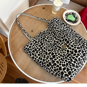 Close-up of leopard print canvas tote bag with handmade label on a rustic wooden table