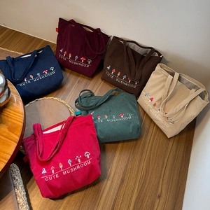 Close-up of colorful corduroy tote bags with cute mushroom embroidery in multiple colors