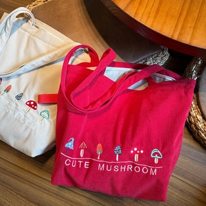 Close-up of cute mushroom embroidery and textured corduroy fabric on a large tote bag