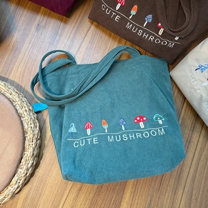Detailed embroidery of colorful mushrooms and cute text on various corduroy tote bags