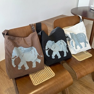 Detailed view of elephant print canvas tote bags with vintage plaid handles in three colors